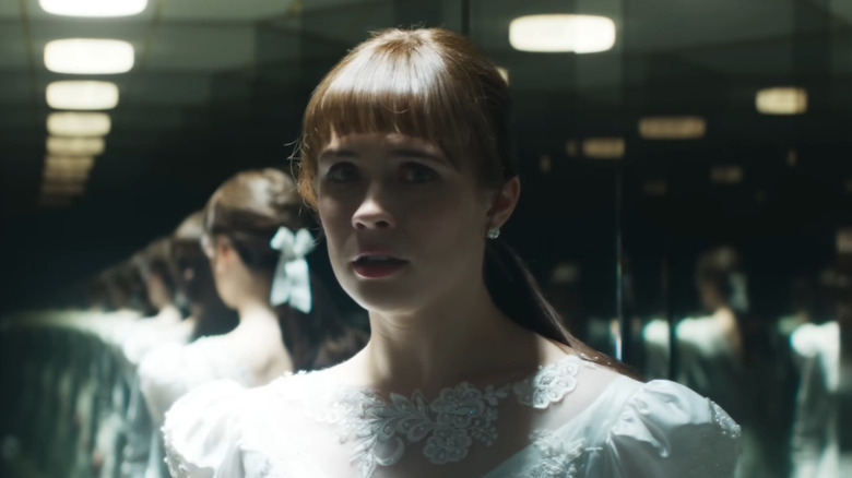 Judy with a scared expression surrounded by mirror reflections in The Conjuring: Last Rites