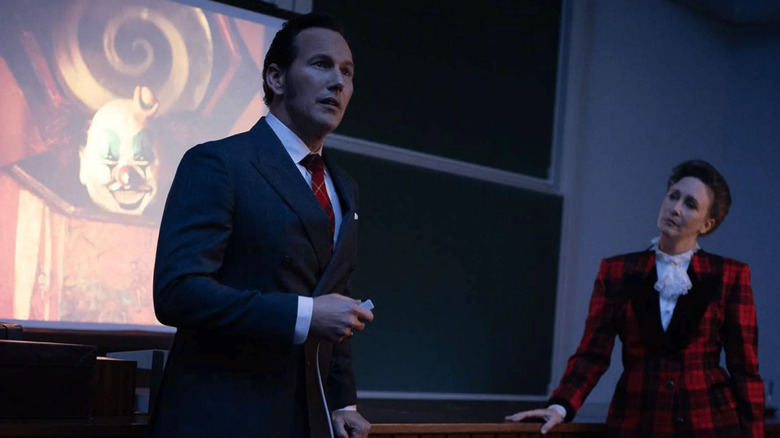 Ed and Lorraine Warren give a presentation on a stage in The Conjuring: Last Rites