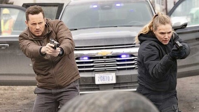 Hailey and Jay point their guns at a suspect outside in "Chicago P.D." (2014-present)