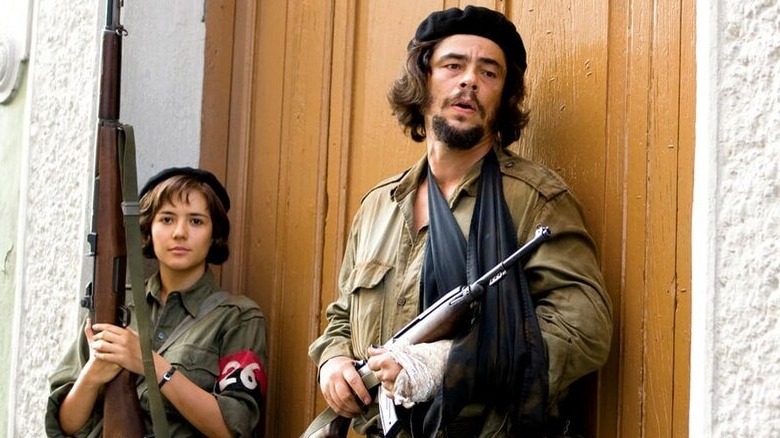Che leans against a door