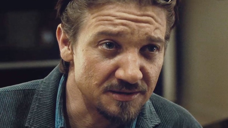 Jeremy Renner with a goatee furrows his brow