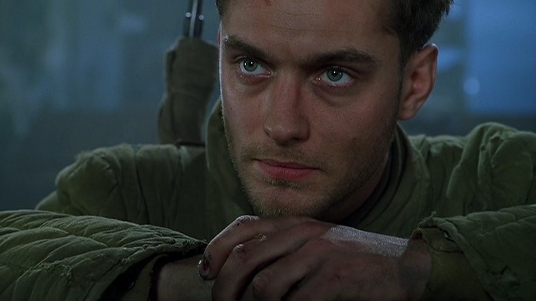 Jude Law as a soldier crosses his arms