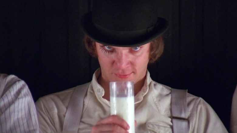 Alex DeLarge holding a glass of milk in A Clockwork Orange