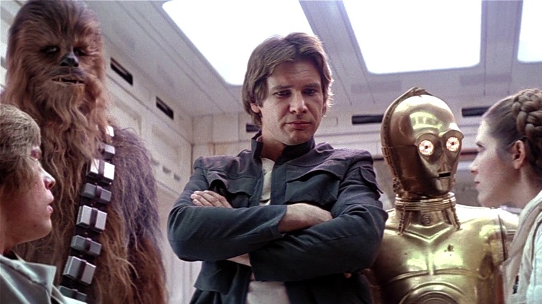Luke, Chewy, Han, C-3PO, and Leia huddled together (1980)