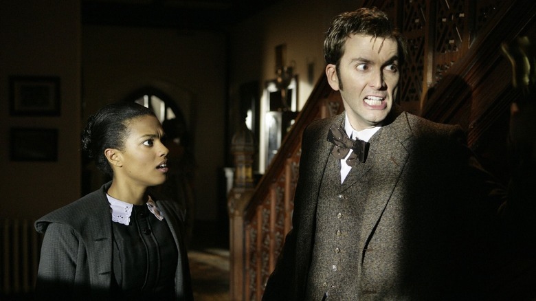 The Doctor and Martha looking scared in shadowy house (2007)