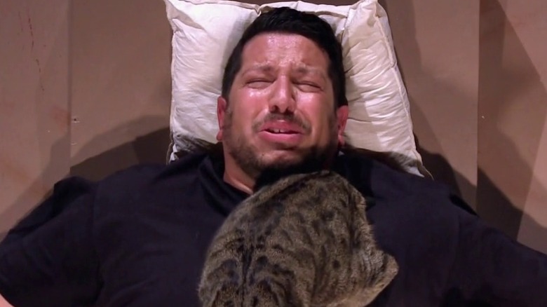Sal crying with cats on chest