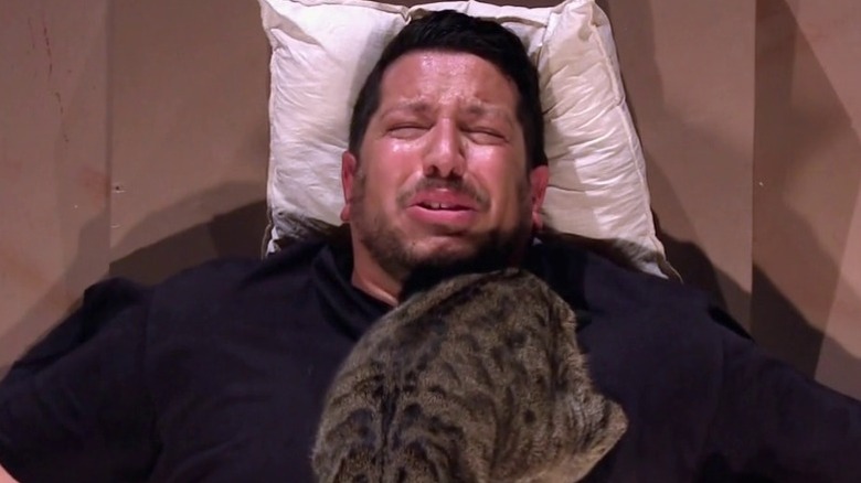 Sal crying with cats on chest