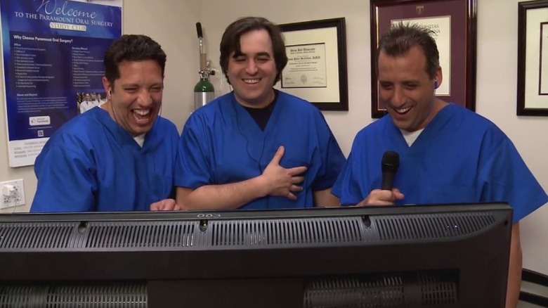 Sal, Q, and Joe laughing behind monitor