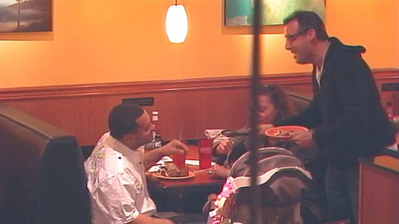 Joe trying to grab food with tongs