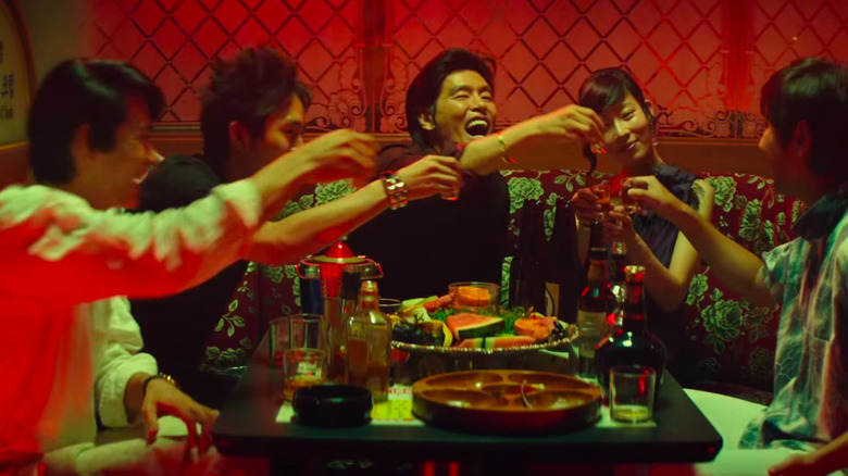 Men in a bar, seated and toasting