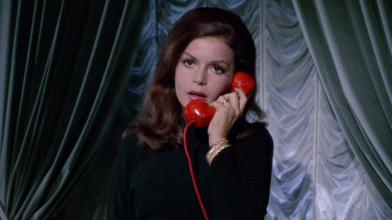 A red mannequin reaches for a model