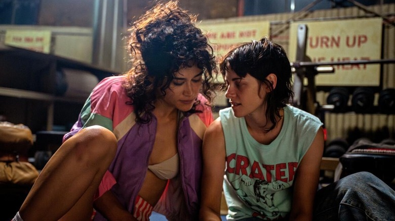 Jackie and Lou sitting together in a weight room in Love Lies Bleeding (2024)