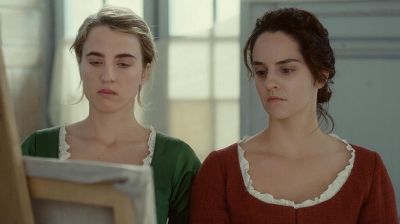 Marianne and Heloise looking at a canvas in Portrait of a Lady on Fire (2019)