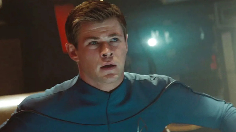 Lieutenant George Kirk looks up in concern while aboard a spaceship in his blue Starfleet uniform in "Star Trek"