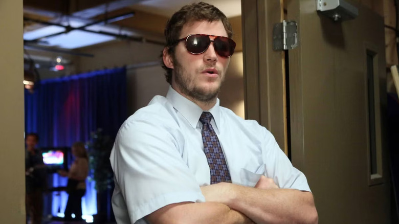 Andy Dwyer crosses his arms while wearing large brown sunglasses in "Parks and Recreation"