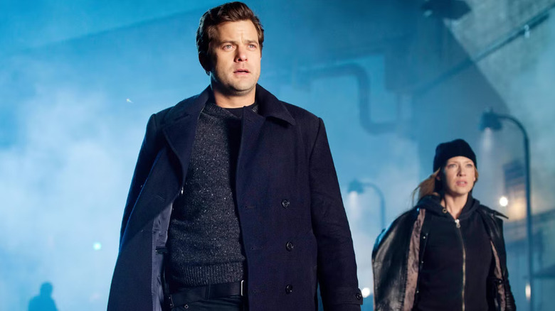 Peter Bishop wears a blue jacket and sweater on a foggy street in "Fringe"