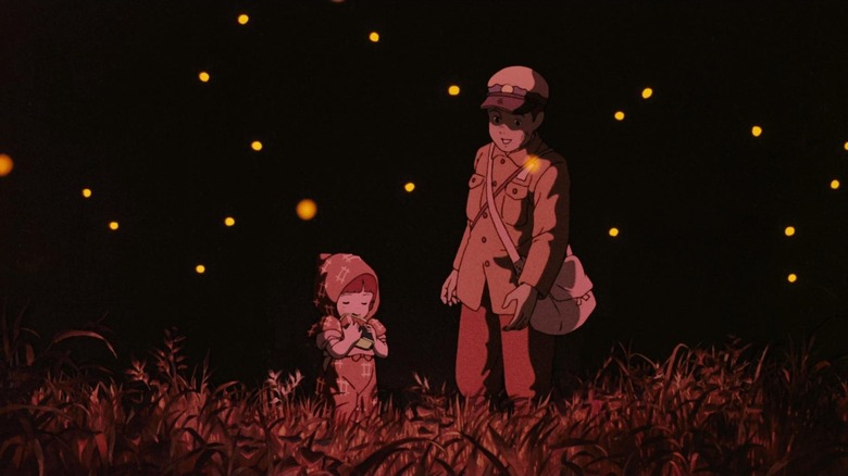 Seita and Setsuko in a field with fireflies in Grave of the Fireflies