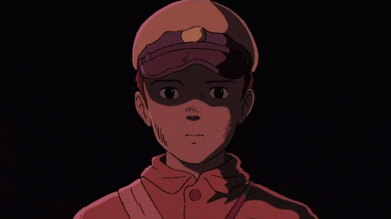 Seita basked in a red glow in Grave of the Fireflies