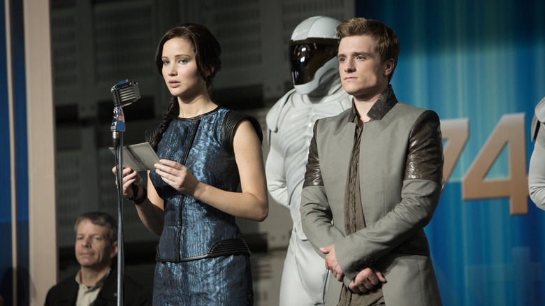 Katniss and Peeta at the mic in District 11 in The Hunger Games: Catching Fire