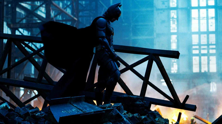 Batman standing in the wreckage of a building in The Dark Knight