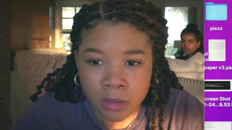 Sky looking at her screen with her friend Veena sitting on the couch in "Missing."