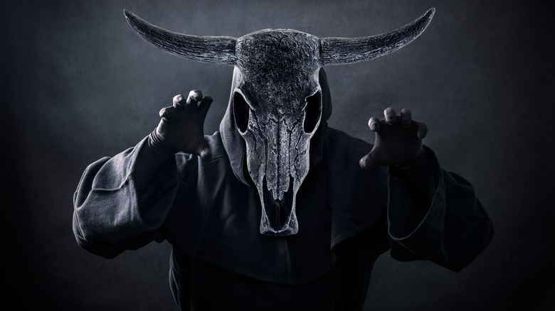 A dark figure with a goat's head