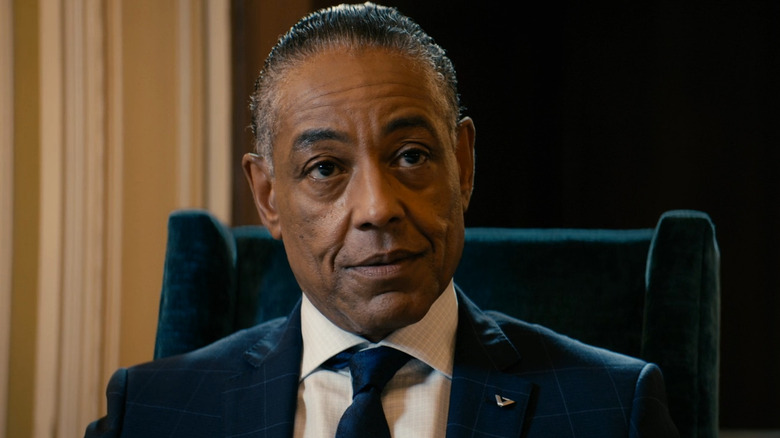 Stan Edgar in a suit sitting in a chair in What I Know