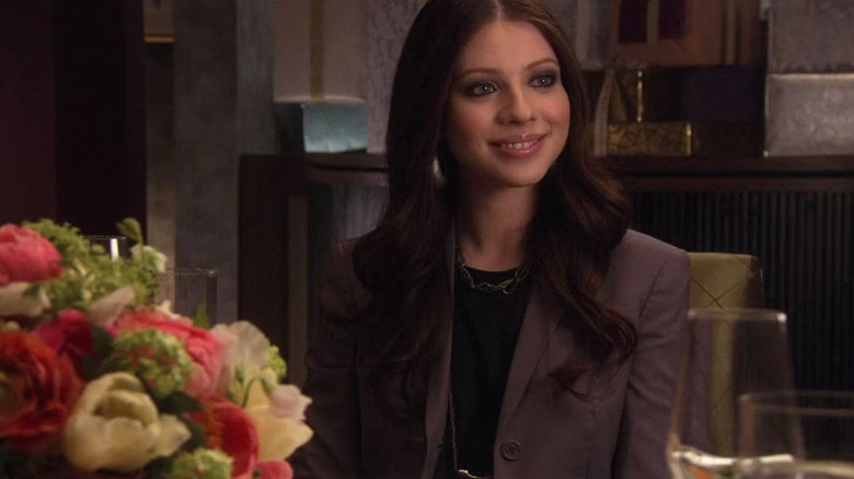 Georgia sitting at the dinner table smiling on Gossip Girl