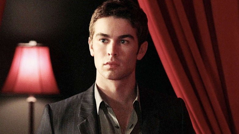 Nate with a red curtain behind him looking confused on Stranger Things