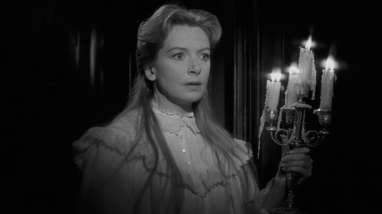 Miss Giddens investigates the strange sounds in "The Innocents" (1961)