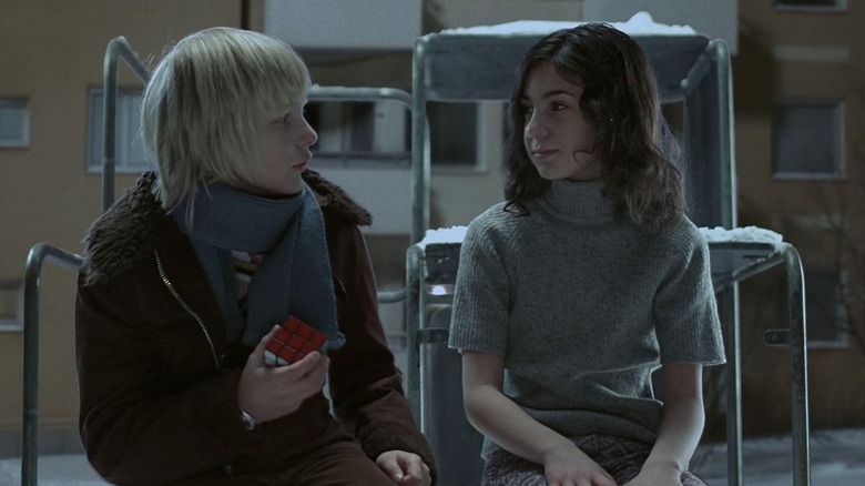 Oskar and Eli in one of their first snowy conversations in Let the Right One In (2008)