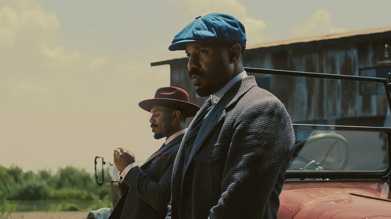 Smoke and Stack leaning against a car in "Sinners"