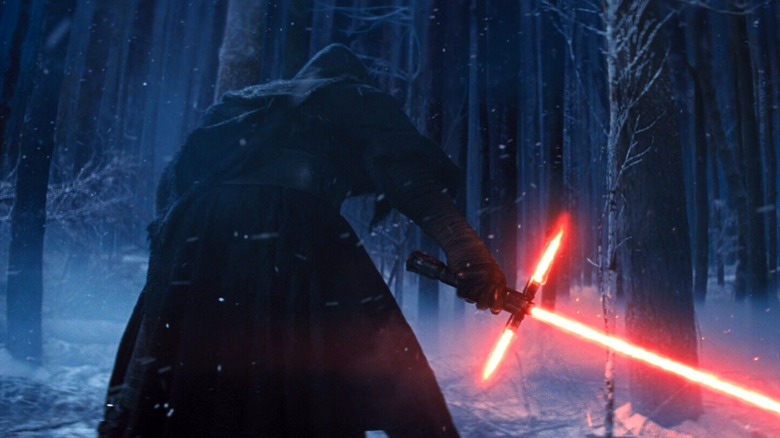 Kylo Ren from behind, brandishing his lightsaber, in "Star Wars: The Force Awakens."