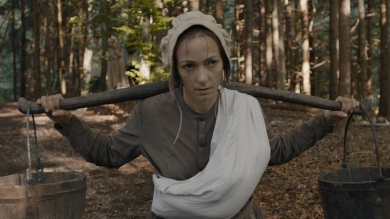 Albrun carrying two buckets in Hagazussa: A Heathen's Curse