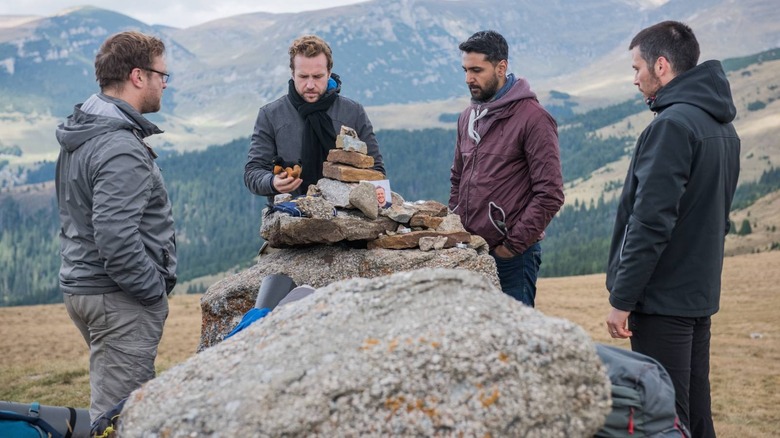 Luke, Phil, Hutch, and Dom stacking rocks in The Ritual