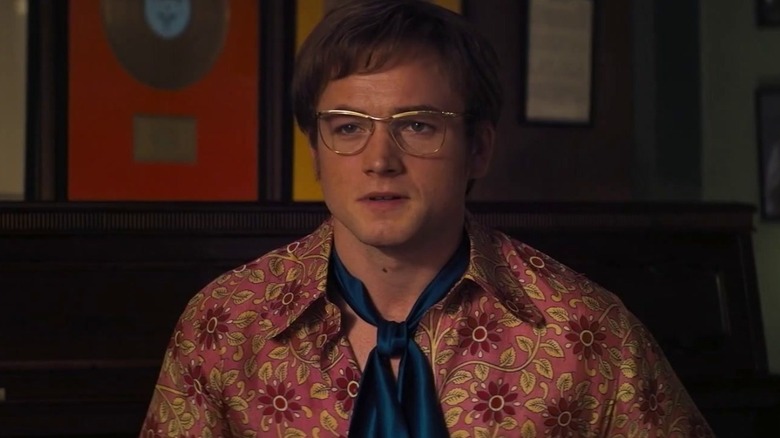 Elton in a floral print shirt and blue tie in Rocketman (2019)