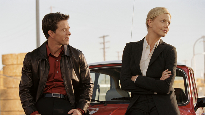 Croker and Stella talk, leaning on the hood of a car, in The Italian Job