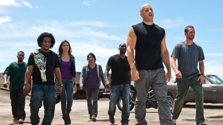 Dominic, Brian, Roman, and more walking near cars in "Furious 7" (2015)