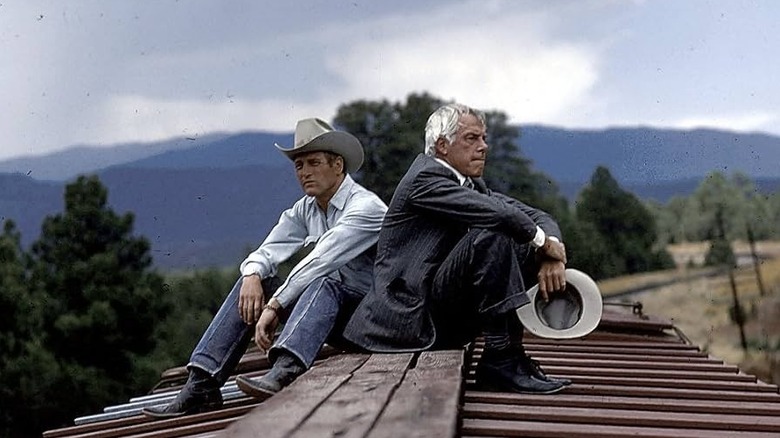 Jim and Leonard sitting on a structure looking pensive in Pocket Money