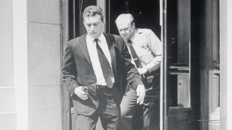 Det. Flint running outside with an officer behind him in Naked City (1958)