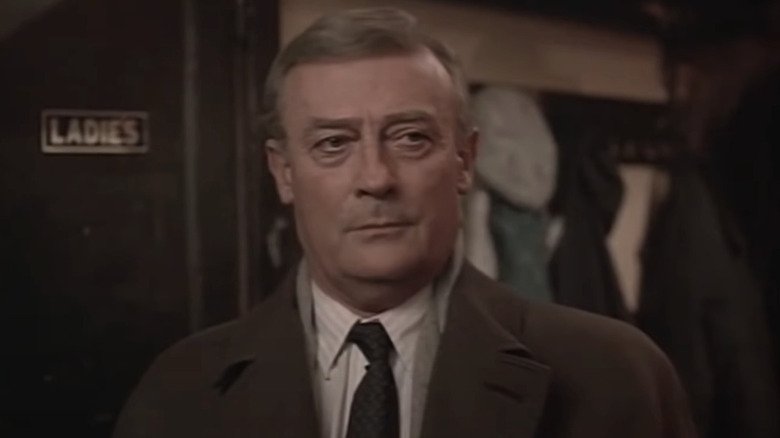 McCall standing near the ladies restroom in The Equalizer (1985)