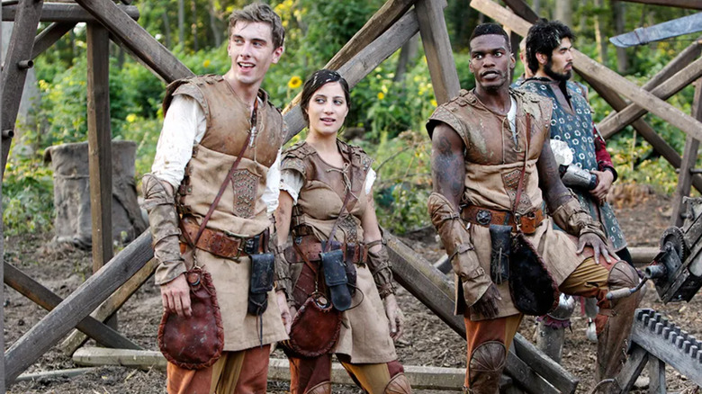 Contestants wearing medieval outfits on the reality show The Quest (2014)