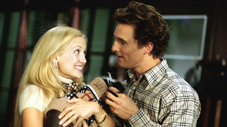 Andie holding a dog in a sweater and Ben petting it in How to Lose a Guy in 10 Days