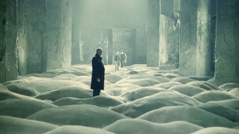 men stand in a sandy, rippled, yet enclosed area of The Zone in "Stalker" (1979)