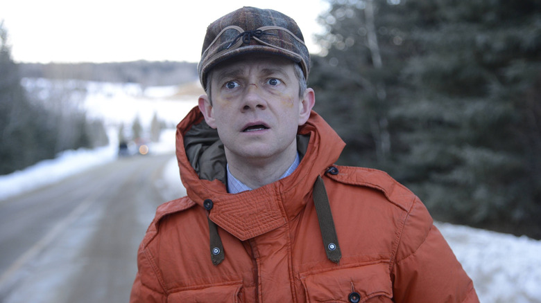 Lester (Martin Freeman) in orange coat looking shocked in Fargo
