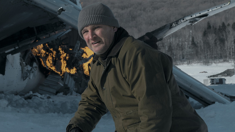 Frank (Jason Clarke) kneeling in front of plane crash in The Last Frontier