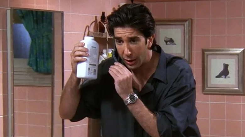 Ross holding a bottle of talcum powder on Friends
