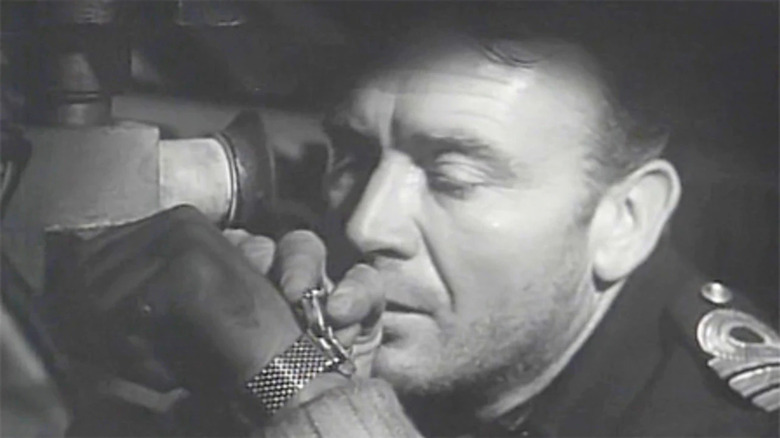 Commander Fraser checks his watch in Above us the Waves (1955)