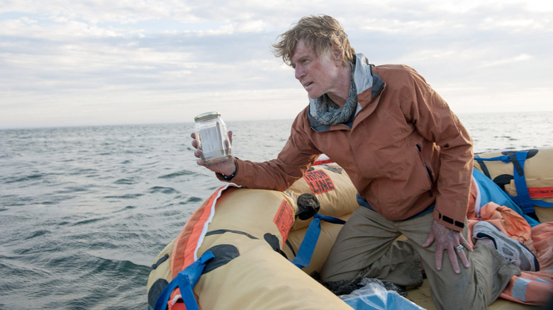 A man holding a jar on a life raft in All is Lost
