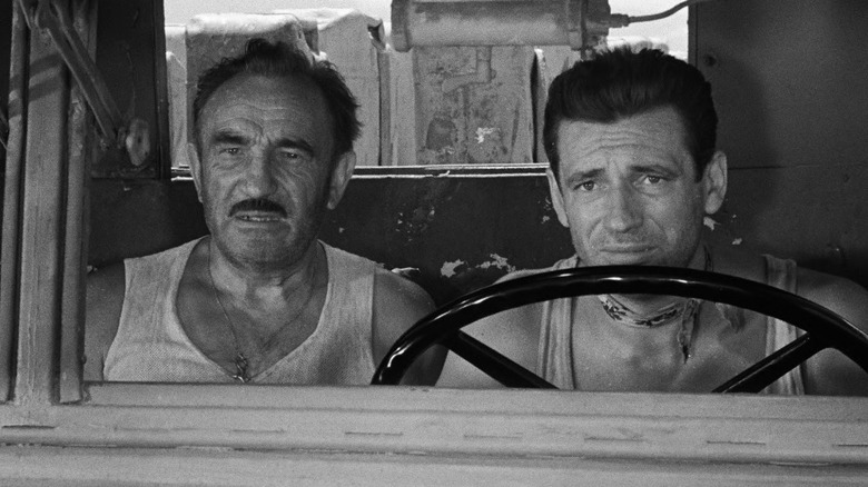 Mario and Jo in the front seat of the truck looking worried in The Wages of Fear